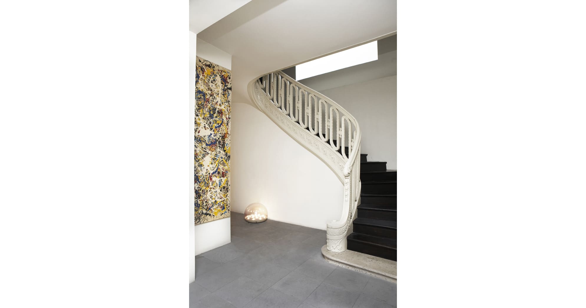 Situé au fond d'une grande cour, cet hôtel particulier classé du début du 19ème siècle, souffrait d'une distribution des pièces exiguë et d'une décoration aux couleurs sobres et chargée de mobilier. Le choix de matériaux naturels (pierre de lave pour le sol, plaquage en Wengé mat pour les portes sur pivots) et la mise en valeur des éléments conservés (escaliers d'accès à l'étage, châssis extérieurs) renforcent la volonté d'un aménagement sobre et minimal, tout en optimisant les volumes de ce lieu étonnant au cœur de Saint-Germain-des-Prés.