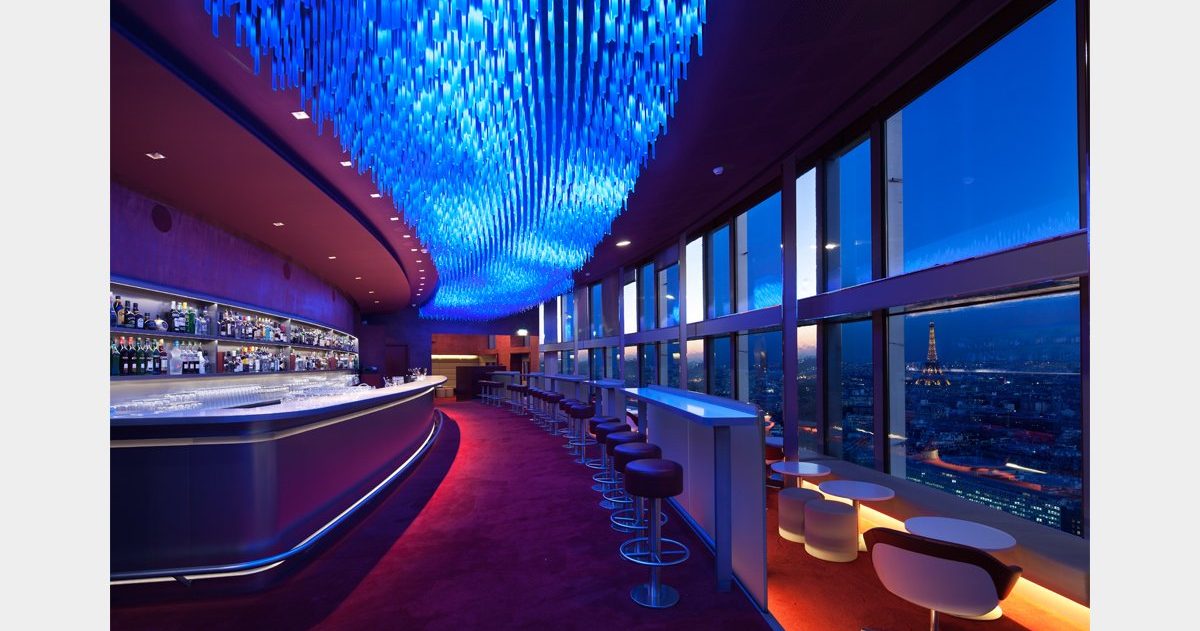 En arrivant au Bar "La Vue", vous pouvez expérimenter deux sensations spatiales opposées et distinctes, qui ne dépendent ni de la décoration ni du mobilier. Tout d'abord, vous pouvez ressentir une sensation de compression en vous déplaçant dans le noyau central du bâtiment, puis, en vous approchant des baies vitrées, vous pouvez éprouver un sentiment d'ouverture et d'expansion. Le design cherche à créer une interface architecturale qui transforme cette opposition en une expérience sensorielle enrichissante. Le sol et le plafond sont conçus pour faciliter l'expression et la perception de ces conditions. En effet, trois marches en contrebas du niveau d'accès principal, associées à trois plans de plafond qui se dilatent, augmentent l'angle de perception et créent une sorte d'image de kaléidoscope.