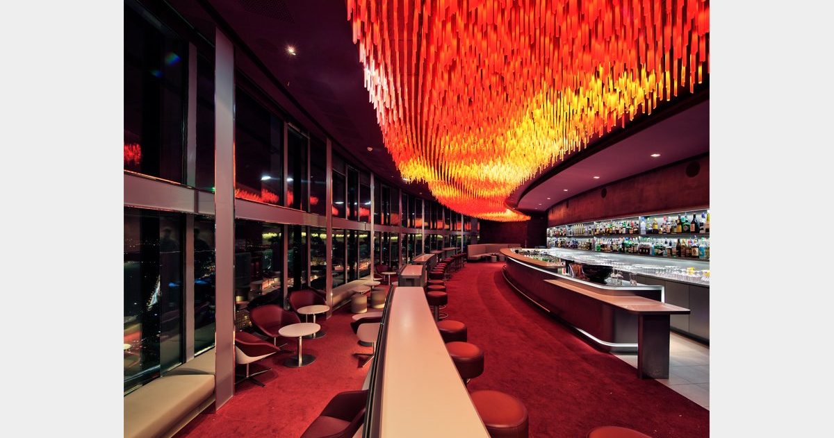 En arrivant au Bar "La Vue", vous pouvez expérimenter deux sensations spatiales opposées et distinctes, qui ne dépendent ni de la décoration ni du mobilier. Tout d'abord, vous pouvez ressentir une sensation de compression en vous déplaçant dans le noyau central du bâtiment, puis, en vous approchant des baies vitrées, vous pouvez éprouver un sentiment d'ouverture et d'expansion. Le design cherche à créer une interface architecturale qui transforme cette opposition en une expérience sensorielle enrichissante. Le sol et le plafond sont conçus pour faciliter l'expression et la perception de ces conditions. En effet, trois marches en contrebas du niveau d'accès principal, associées à trois plans de plafond qui se dilatent, augmentent l'angle de perception et créent une sorte d'image de kaléidoscope.