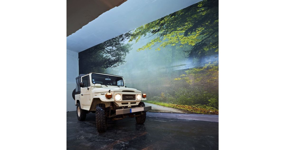 Le plafond noir mat et le balisage fluorescent apportent un effet cinétique à ce lieu de présentation de véhicules haut de gamme. Les impressions numériques haute définition à thèmes variés "forest", "mountain" et "summer bridge" évoquent l'évasion. Les marquages au sol damier et bandes alternées accentuent l’image sportive de ce lieu automobile.