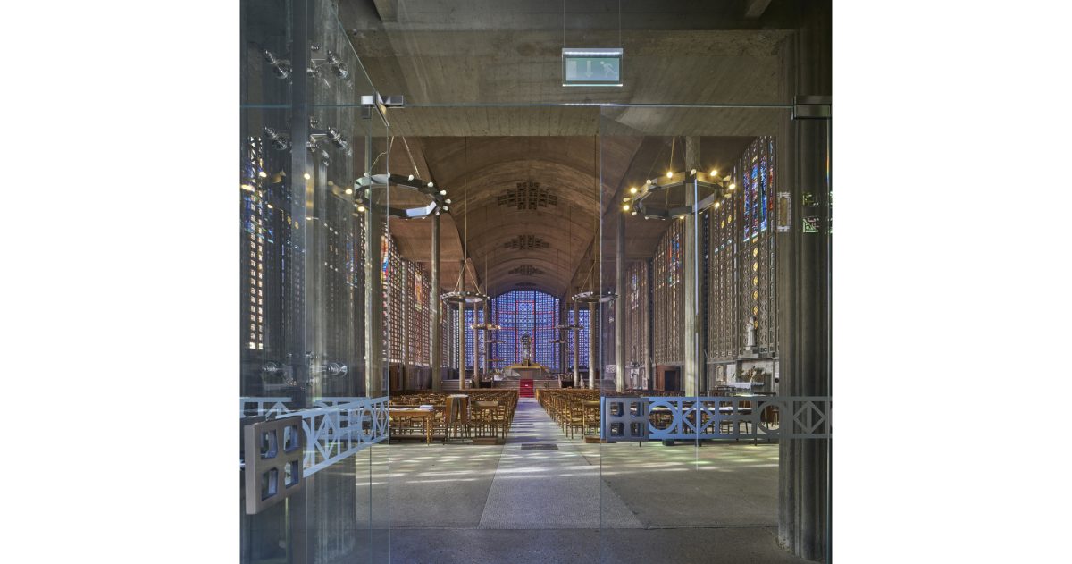 Création d’un sas vitré translucide permettant une vision privilégiée permanente depuis la rue principale sur les volumes et les vitraux de ce lieu d’exception sans que les fidèles ou les touristes ne soient affectés par les intempéries et les bruits émanant de la rue.