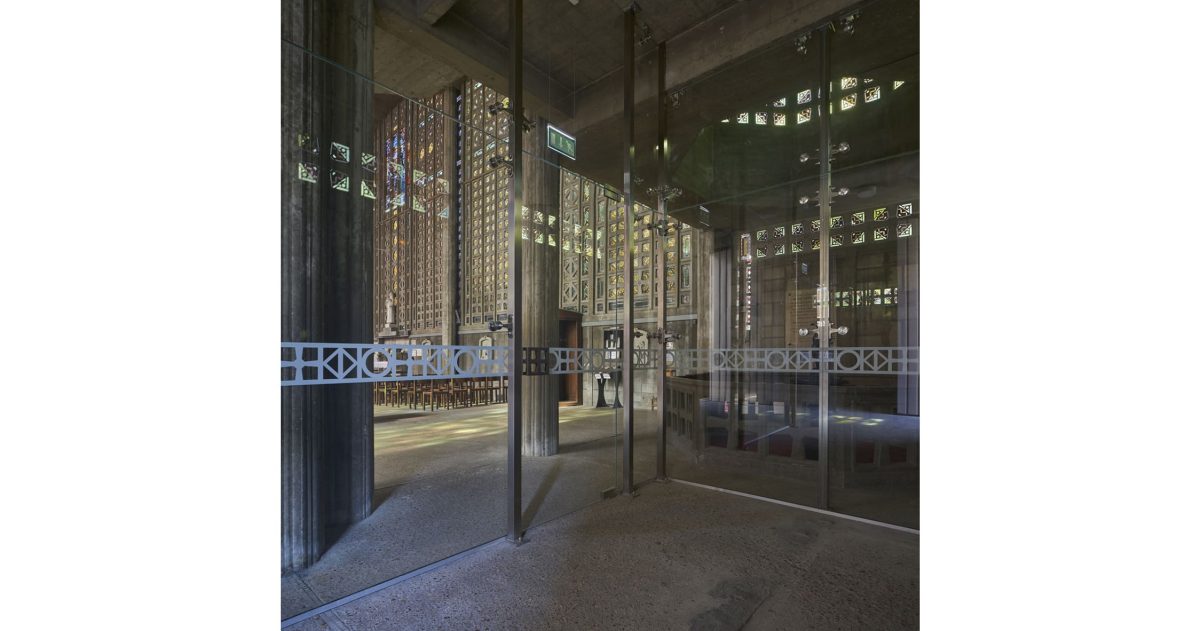 Création d’un sas vitré translucide permettant une vision privilégiée permanente depuis la rue principale sur les volumes et les vitraux de ce lieu d’exception sans que les fidèles ou les touristes ne soient affectés par les intempéries et les bruits émanant de la rue.