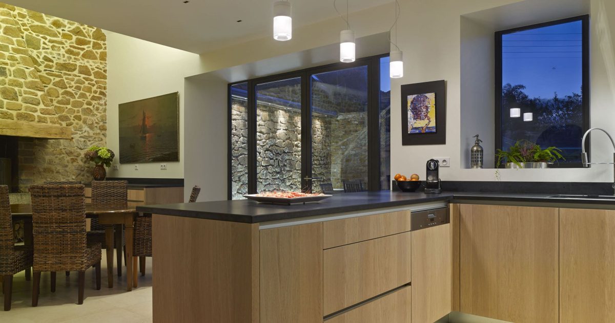 Réhabilitation et rénovation d'un ensemble de cinq corps de bâtiments. Pour pallier la particularité des maisons bretonnes sombres car pourvues de petites ouvertures, la création d'une baie se révélait nécessaire afin d'accroître la luminosité des pièces à vivre. La redistribution des pièces et la mise à niveau des sols au rez-de-chaussée ont permis une optimisation de la superficie en améliorant également la circulation entre les espaces de vie.