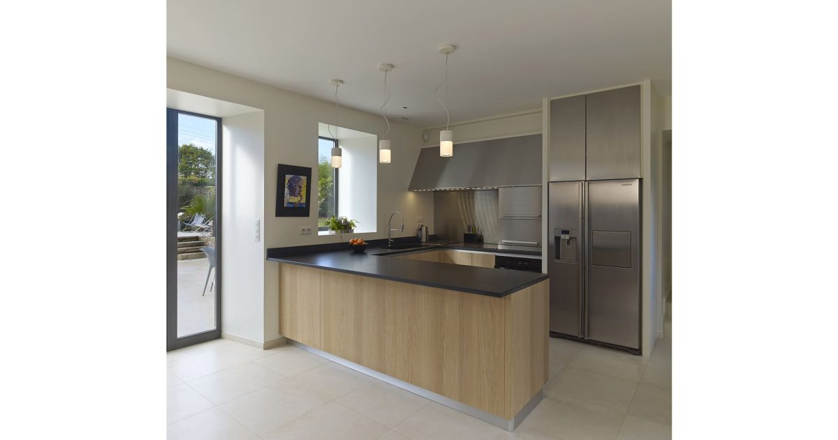 Réhabilitation et rénovation d'un ensemble de cinq corps de bâtiments. Pour pallier la particularité des maisons bretonnes sombres car pourvues de petites ouvertures, la création d'une baie se révélait nécessaire afin d'accroître la luminosité des pièces à vivre. La redistribution des pièces et la mise à niveau des sols au rez-de-chaussée ont permis une optimisation de la superficie en améliorant également la circulation entre les espaces de vie.