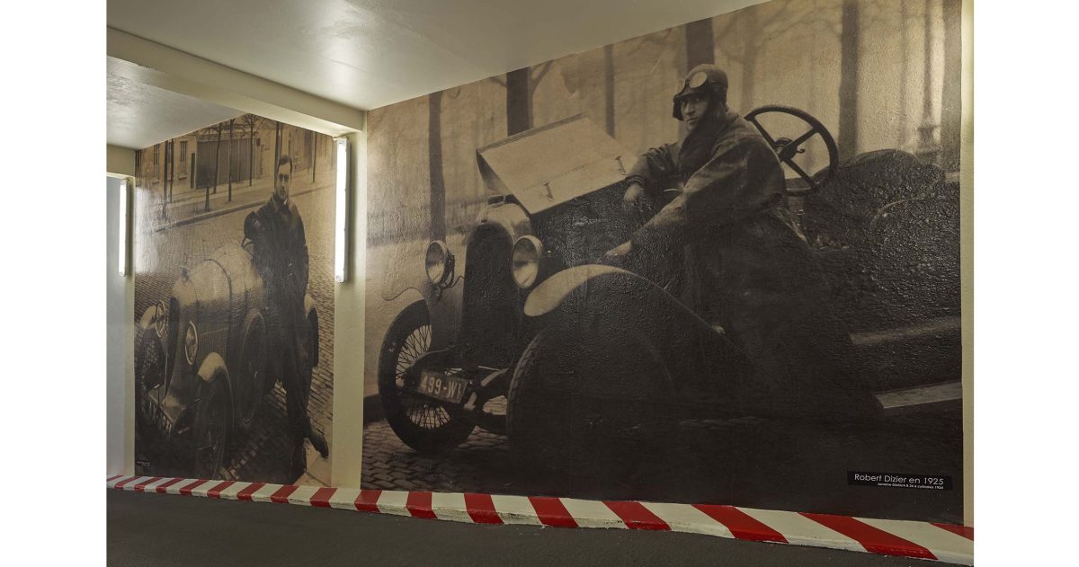 Aménagement d'un accès de garage. Le garage Robert Dizier est reconnu depuis trois générations par les plus grands amateurs de voitures d'exception (Porsche, Lotus, Jaguar, Bentley, ...). Pour référer à la pérennité de cette institution, des impressions numériques HD positionnées sur les murs de la rampe d'accès représentent le fondateur posant devant une Lorraine Dietrich en 1925 et devant une Amilcar en 1938.